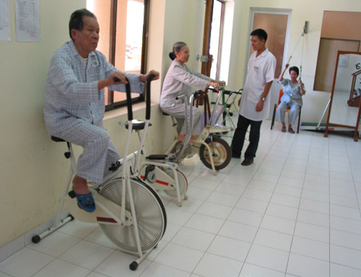 Người già tập xe đạp tập thể dục phục hồi chức năng trong bệnh viện